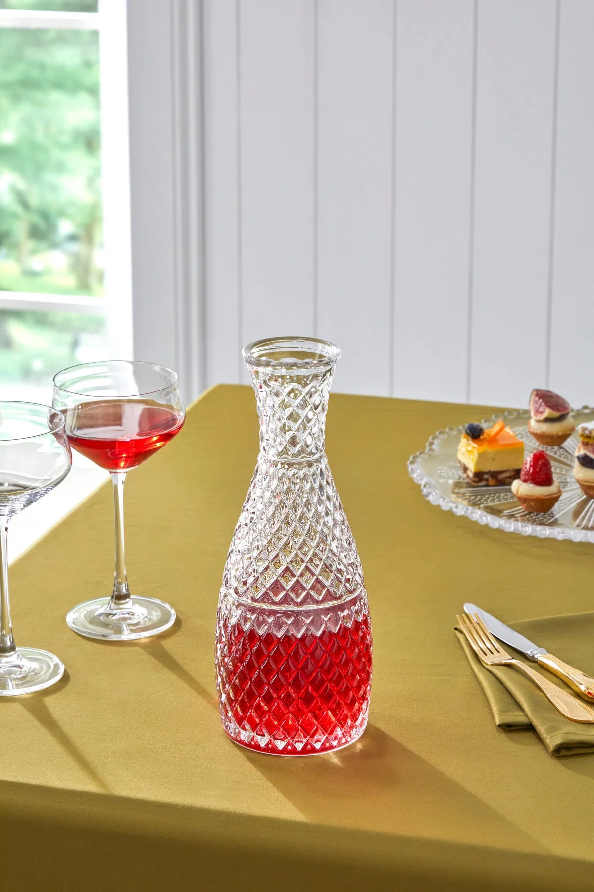bir şarap dekantörü ve iki şarap bardağı bir masada