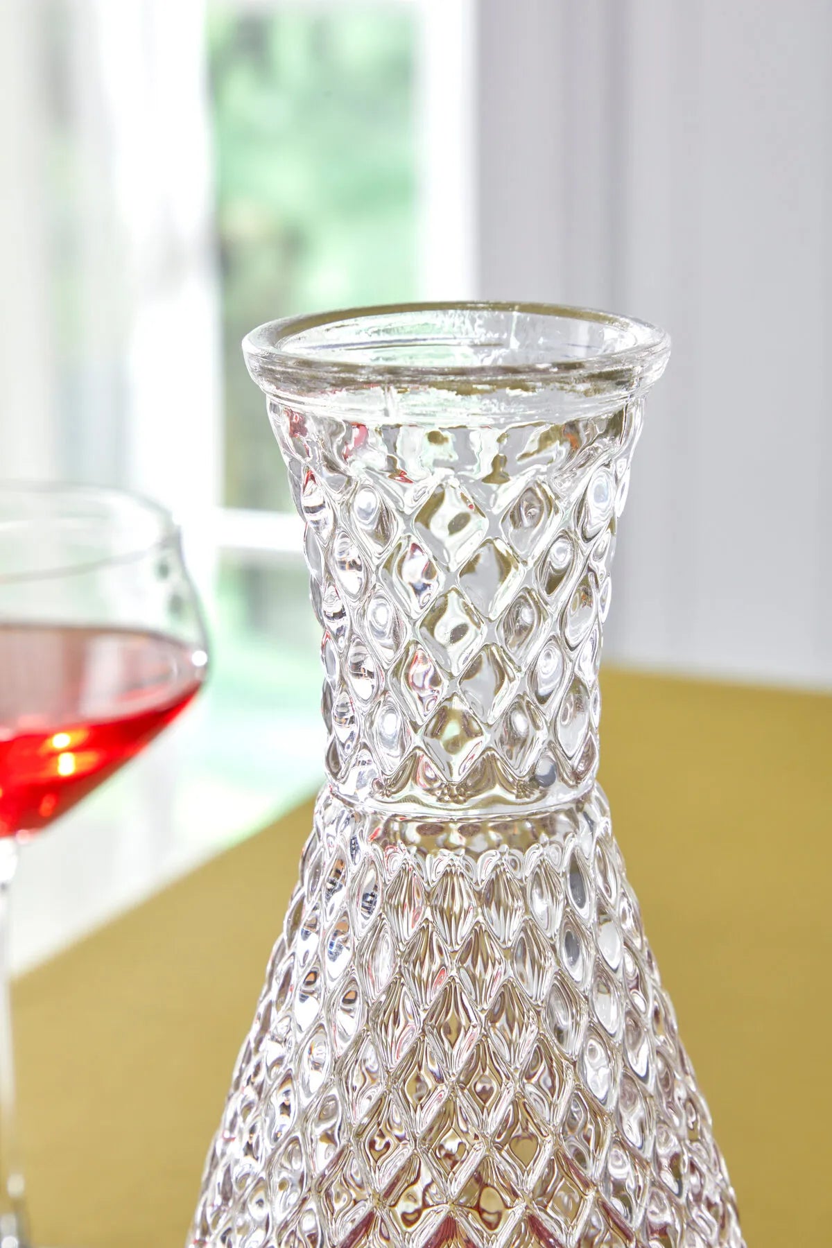bir masa üzerinde bir şarap bardağı ve bir vazo
