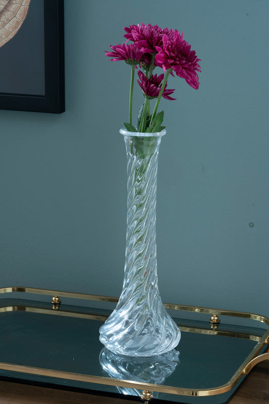 bir tepsi üzerinde içinde çiçekler bulunan bir cam vazo